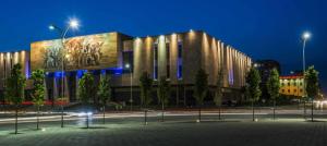 a building with a painting on the side of it at night at Studio Silva in Tirana