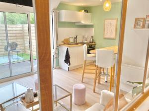 a small kitchen and dining room with a table and chairs at Cocon Maritime - Terrasse privée et plage à pied - 1 chambre & 1 Mezzanine in Ouistreham