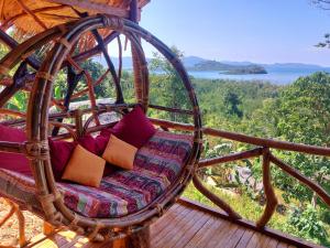 a wicker chair on a porch with a view of the water at Jungle Bar Honeymoon suite & private pool in San Vicente
