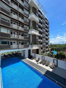a large apartment building with a swimming pool in front of it at Cozy studio unit in a condominium in Iloilo City