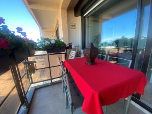 een tafel met een rode tafelkleed op een balkon bij Studio vue mer pour 2 personnes au Port de Valras-Plage in Valras-Plage