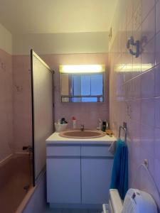 een badkamer met een wastafel, een bad en een spiegel bij Studio vue mer pour 2 personnes au Port de Valras-Plage in Valras-Plage