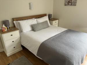 een slaapkamer met een wit bed en 2 nachtkastjes bij Cherry Tree Cottage in idyllic Cotswold village in Chipping Norton