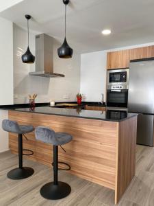a kitchen with a counter and two stools at Casa de Goya in Argés