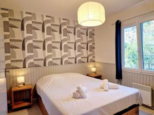 um quarto com uma cama com toalhas em Les Capucines YourHostHelper em Portbail