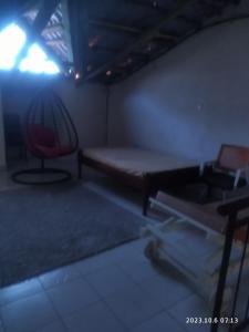 um quarto escuro com uma cama e uma cadeira em Sp Accommodations em Mombasa