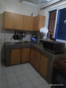 a kitchen with wooden cabinets and a microwave at Sp Accommodations in Mombasa