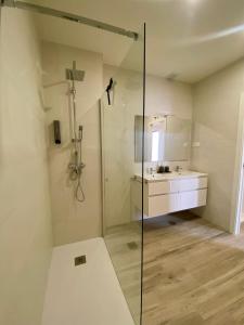 a bathroom with a glass shower and a sink at Casa de Goya in Argés