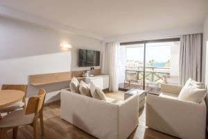 ヘルソニソスにあるヘルソニソス パレスの白い家具付きのリビングルームが備わり、海の景色を望めます。
