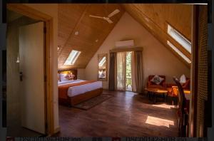 a bedroom with a bed and a couch in a room at Samsara Luxury Cottages & Spa !! Best Resort in Chail in Chail