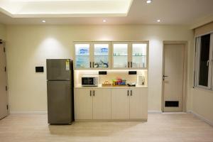 a kitchen with a stainless steel refrigerator and cabinets at Luxury 3BHK Villa in Dharamshala with Jacuzzi in Kangra