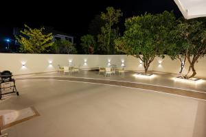 una piscina notturna con sedie e alberi di Luxury 3BHK Villa in Dharamshala with Jacuzzi a Kangra