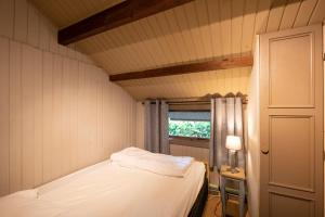 una piccola camera con letto e finestra di Chalet Evergreen a Durbuy