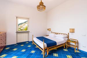 ein Schlafzimmer mit einem Bett und blauen Fliesenböden in der Unterkunft Starhost - Villa Marcella con terrazza e giardino vista mare in Vietri