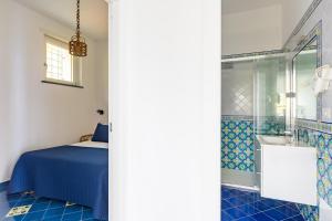 ein Schlafzimmer mit einem Bett und ein Badezimmer mit Dusche in der Unterkunft Starhost - Villa Marcella con terrazza e giardino vista mare in Vietri + 115 Fotos