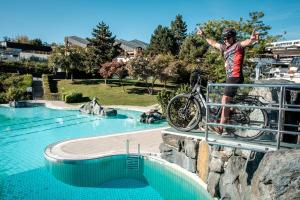 un hombre en una bicicleta en un carril cerca de una piscina en Gmiatliche Stubm, en Loipersdorf bei Fürstenfeld