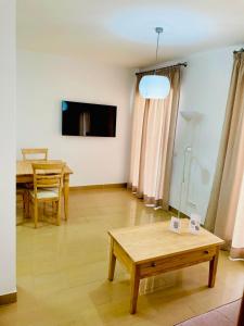 a living room with a table and a tv at Acantilados De Maro in Maro