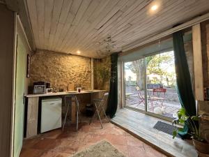 una pequeña cocina con encimera y ventana en Chambre d’hôte avec Sauna & Jacuzzi, en Les Lèves-et-Thoumeyragues