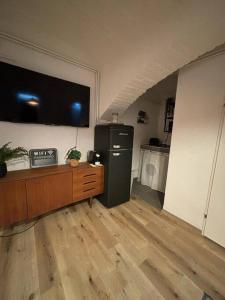 Zimmer mit einem Kühlschrank und einem TV an der Wand in der Unterkunft Trendy Souterrain Loft - Near City Center in Wien