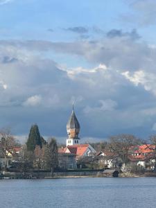 um grande edifício com uma torre de relógio ao lado de um lago em Apartment Weßling em Wessling