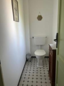 a bathroom with a toilet and a black and white tile floor at Hotel Le Ponteil in Antibes