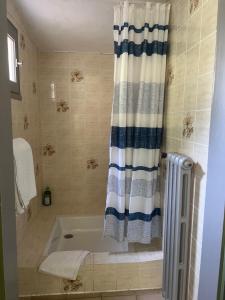 a bathroom with a tub and a shower curtain at Hotel Le Ponteil in Antibes