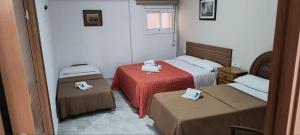 una camera d'albergo con due letti e due di Hostal Europa a Tarragona