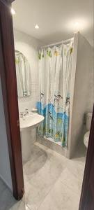 baño con lavabo y cortina de ducha en Hostal Europa en Tarragona