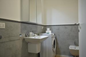 a bathroom with a sink and a washing machine at Welc-ōM Padova Santa Sofia in Padova