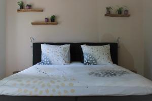 a bed with a black headboard and two pillows at bloom-inn gastvrij genieten in Doornenburg