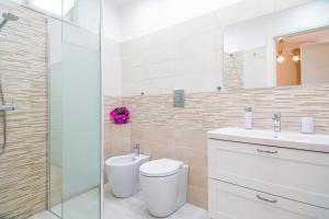 a bathroom with a toilet and a sink and a shower at L'Antico Cortile di Alba in Viagrande +23 photos