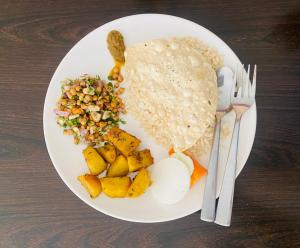 einen Teller mit Reis und Gemüse auf dem Tisch in der Unterkunft Eco Adventure Resort in Sauraha
