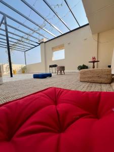 a red bed in a room with a large window at Luxury 4BHK Penthouse with Theatre, Jacuzzi & Private Terrace in Navi Mumbai