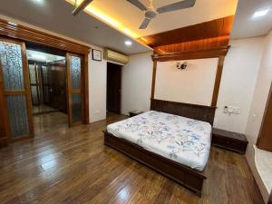1 dormitorio con 1 cama en una habitación con suelo de madera en Luxury 4BHK Penthouse with Theatre, Jacuzzi & Private Terrace en Navi Mumbai