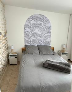 a bedroom with a bed with a large headboard at Le Patio - Saint-Denis d’Oléron in Saint-Denis-dʼOléron