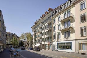 - un bâtiment dans une rue avec des voitures garées à côté dans l'établissement Sorell Hotel Arabelle, à Berne
