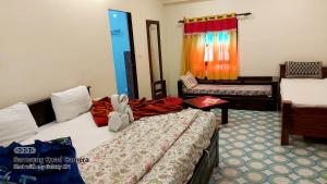 um quarto de hotel com duas camas e um sofá em Rani Mahal Hotel em Jaipur
