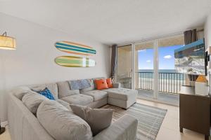 Una sala de estar con un sofá y una ventana grande. en Oceania Plaza 405, en New Smyrna Beach