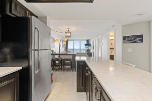 cocina con nevera y comedor en Oceania Plaza 405, en New Smyrna Beach