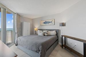 Un dormitorio con una cama con vista al mar. en Oceania Plaza 405, en New Smyrna Beach 39 fotos más