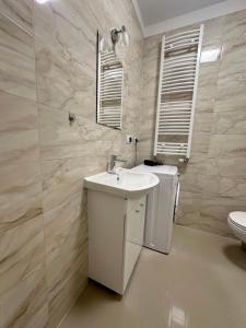 a white bathroom with a sink and a toilet at Apartament ŻELAZNY HGS Home in Gorzów Wielkopolski
