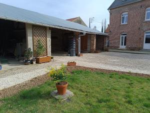 a house with a yard with some flowers in the grass at AU COEUR DE L'ENCLAVE in Moeuvres