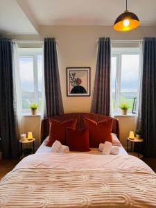 una camera da letto con un grande letto con cuscini rossi di Finnstown Hall a Dublino