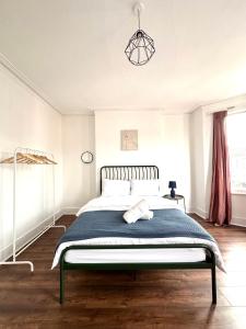 a bedroom with a bed with a blue blanket at Charming, Renovated Residence in Willesden Green in London