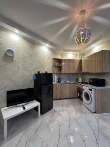 cocina con nevera, lavadora y secadora en Rustaveli Apartment 113, en Kutaisi