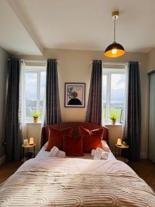 una camera da letto con un grande letto con due finestre di Finnstown Hall a Dublino