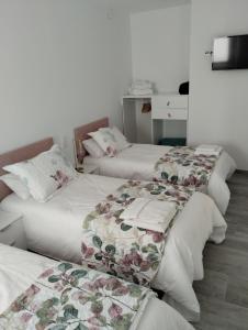 un grupo de 3 camas en una habitación en Louridoplaya en Poio