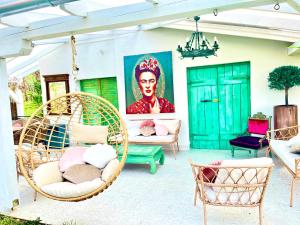 a patio with chairs and a painting of a woman at Bohemian Eco Lodge at lake Balaton in Kisapáti