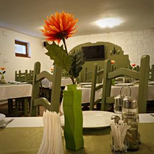 una flor en un jarrón sobre una mesa en un restaurante en Hanul Vestem, en Sibiu