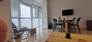 ein Wohnzimmer mit einem Tisch, Stühlen und einem TV in der Unterkunft ARENA y Mar Sunny Home by Cadiz4Rentals in Cádiz